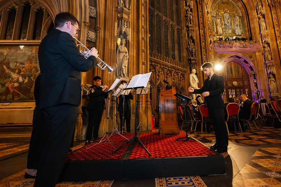 Five trumpeters performing in a grand hall 